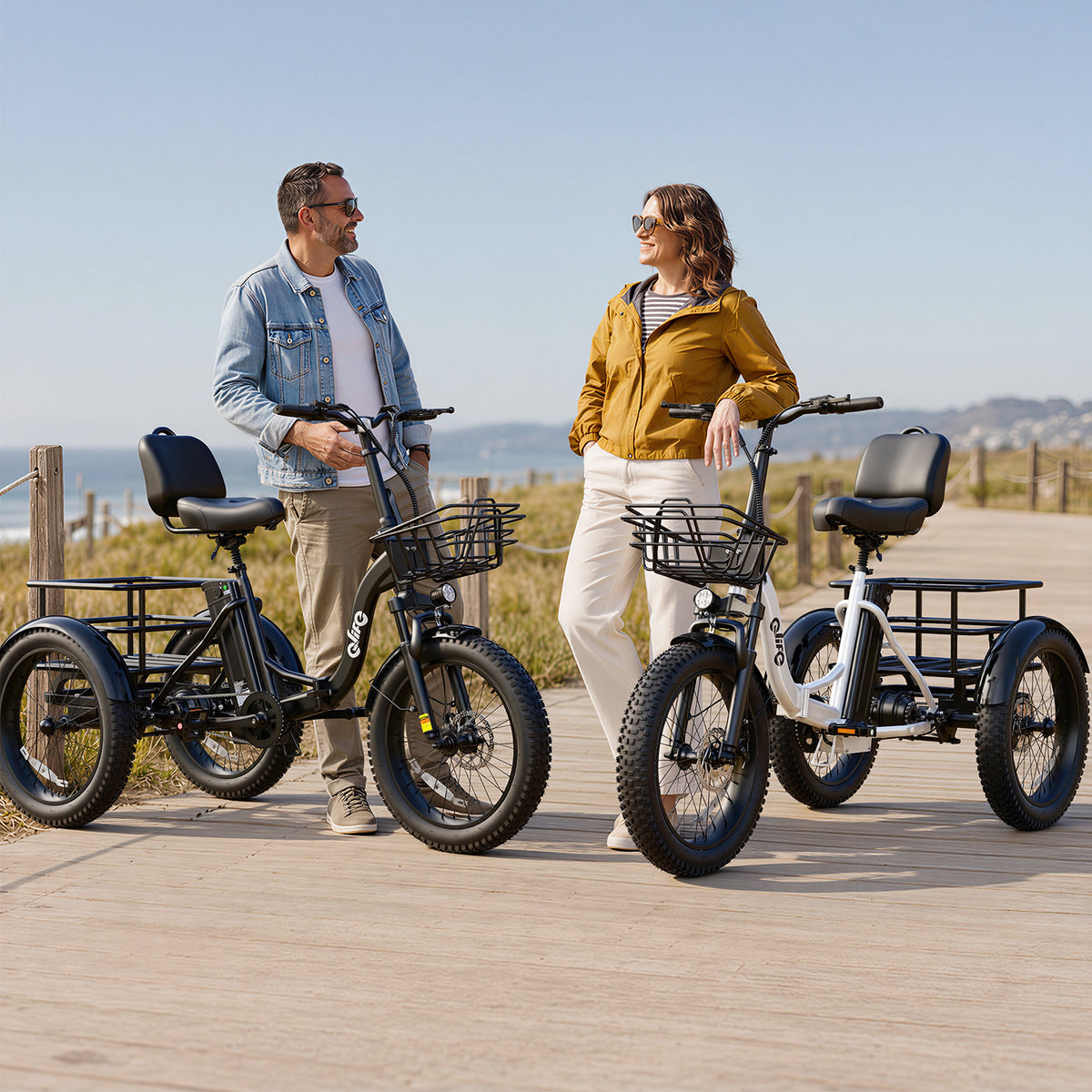 Supplier lifestyle photo showing black and white Qlife electric tricycles beside a couple on a coastal path