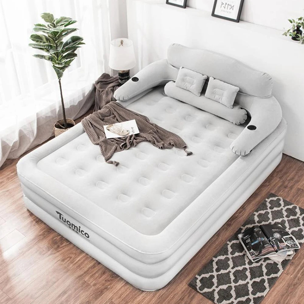 Inflatable bed with armrests in a room setting with decor elements.
