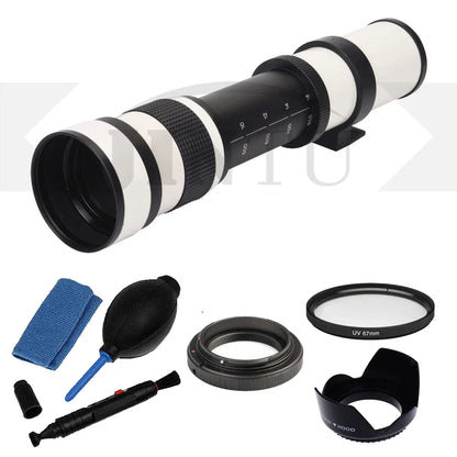 A long-focus camera telephoto lens with a black and white body, shown with included accessories on a light gray background: a blue microfiber cloth, bulb blower, cleaning tool, lens filter, adapter ring, lens hood, and lens cap.